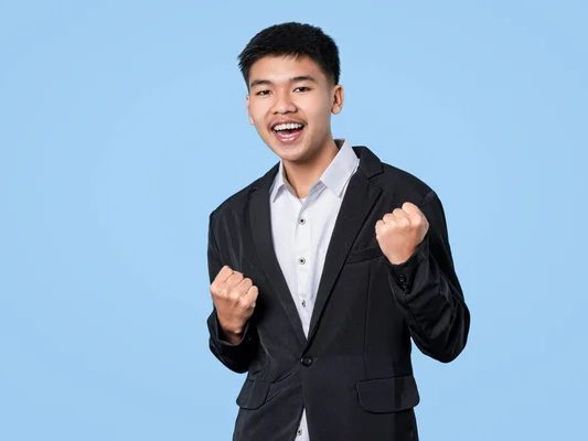 Jeune homme souriant, poings levés en signe de victoire